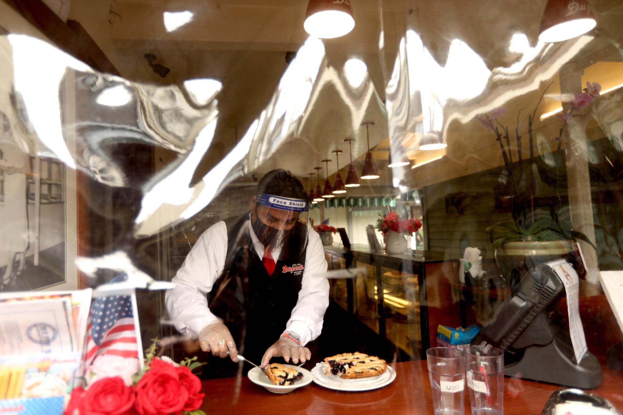 Jose Mlgar cuts a piece of pie for a customer at Du-par's restaurant.