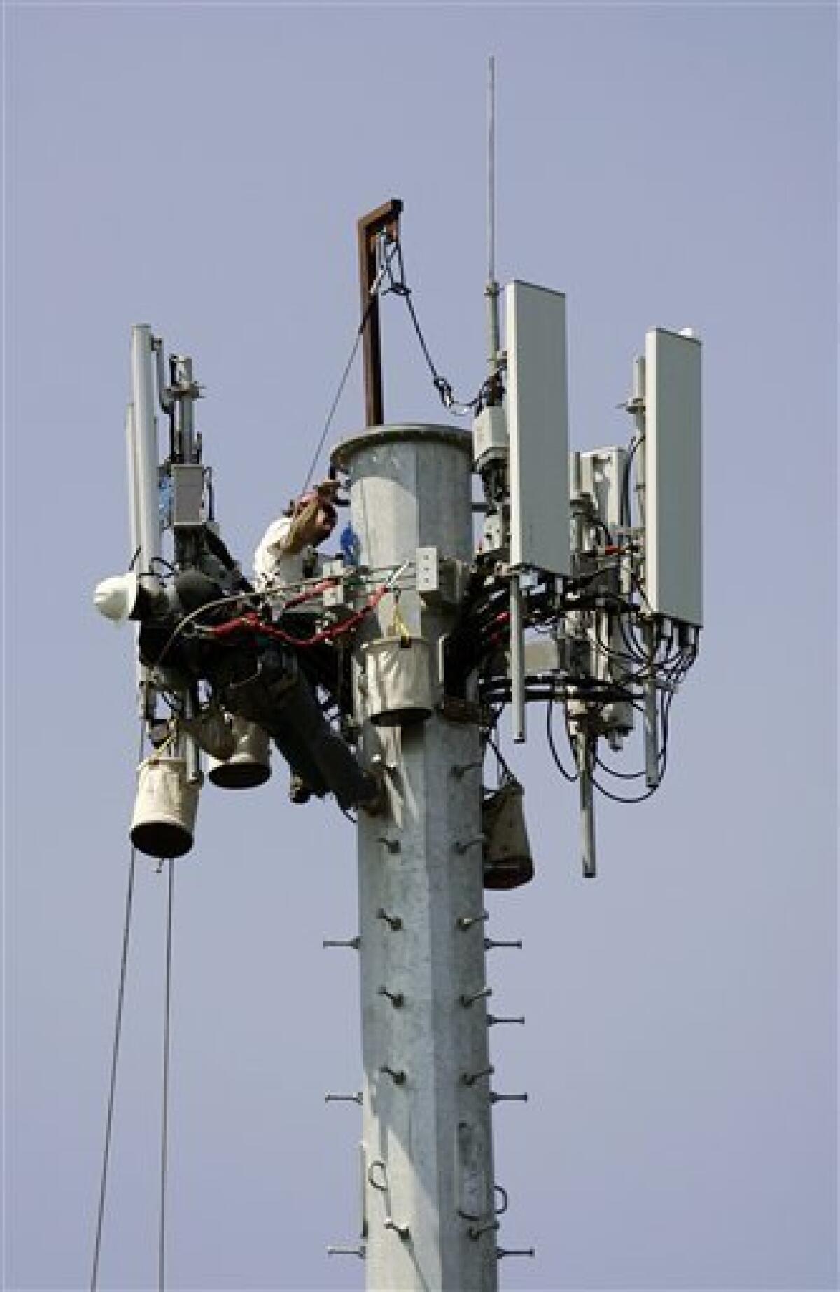 In this file photo taken July 16, 2008, workers are seen at the construction of a cellular telephone antenna tower in Lakewood, N.J.. A Long Island township has imposed restrictions on the placement of new cell towers that are among the toughest in the country, and one phone company said, Thursday, Sept. 23, 2010, it effectively bans new construction. (AP Photo/Mel Evans, File)