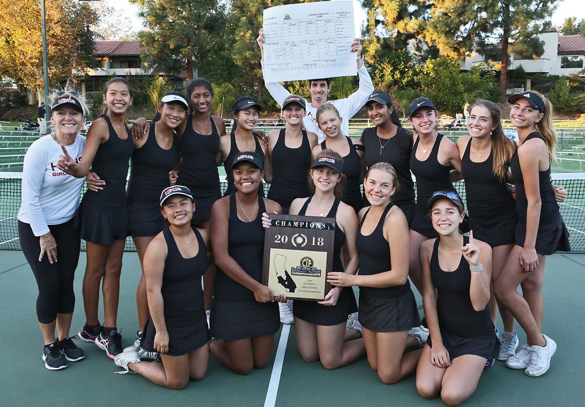 The Huntington Beach High girls' tennis team celebrates its CIF Southern Section Division 3 championship win against Laguna Beach at the Claremont Club on Friday.