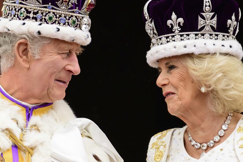Britain's King Charles III and Queen Camilla look at each other as they stand on the balcony of the Buckingham Palace after their coronation, in London, Saturday, May 6, 2023. (Leon Neal/Pool Photo via AP)