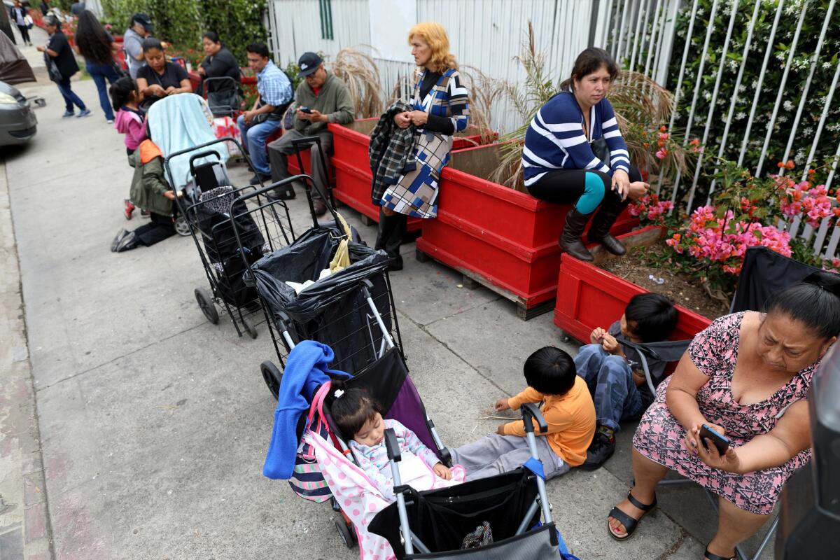 People wait in line for the St. Francis Center food bank to open in Los Angeles. (Gary Coronado / Los Angeles Times)
