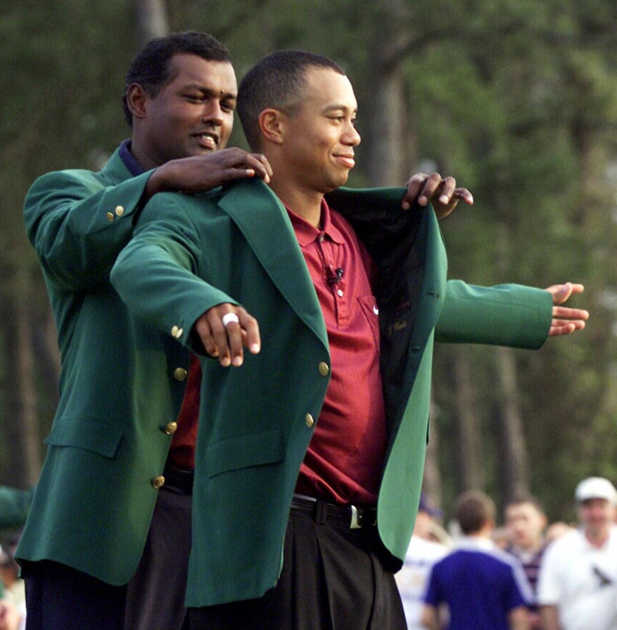 Tiger Woods receiving his Masters green jacket from champion Vijay Singh.