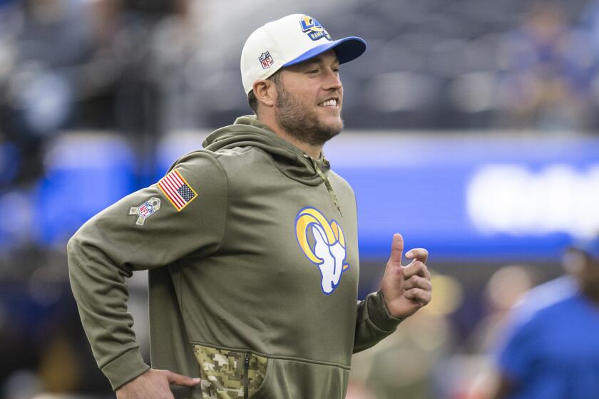 Los Angeles Rams quarterback Matthew Stafford (9) jogs on the field before an NFL football game.