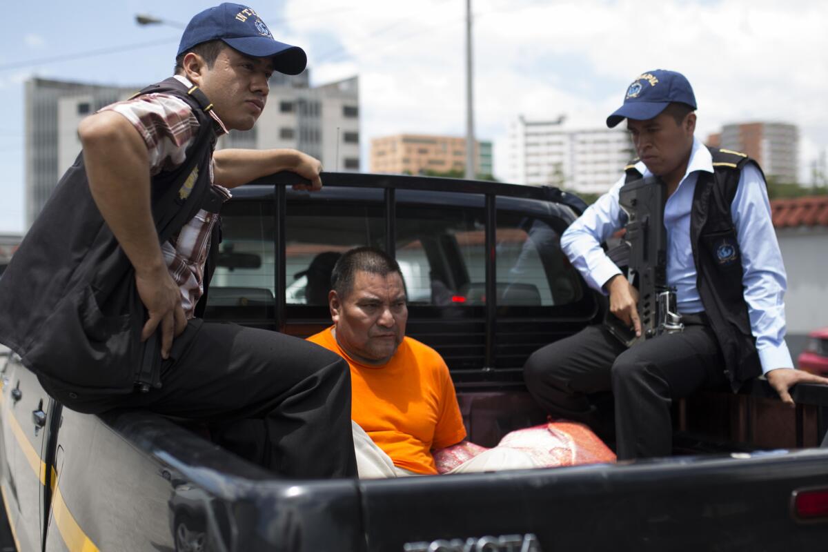 Santos López Alonzo is escoltado por agentes de Interpol después aterrizar en la base de la Fuerza Aérea en Ciudad de Guatemala el miércoles 10 de agosto de 2016. López, acusado de participar en la masacre de más de 160 personas en 1982 durante la guerra civil, fue deportado el miércoles de Estados Unidos a Guatemala después que una corte denegó su pedido de permanecer en territorio estadounidense. (AP Foto/Luis Soto)