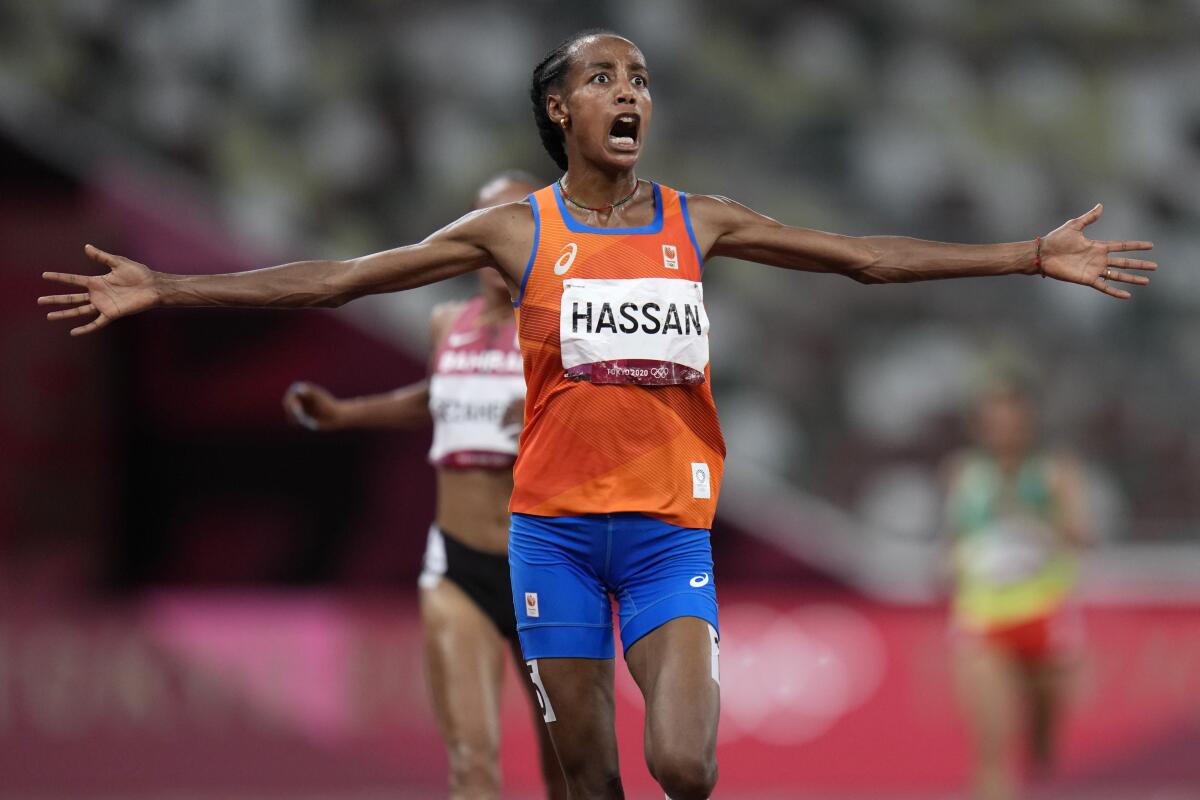 Sifan Hassan of the Netherlands flings out her arms as she wins the women's 10,000 meters at the Tokyo Olympics.