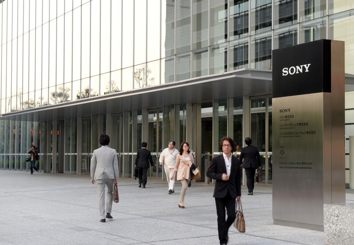 Visitors walk at the entrance of Sony headquarters building in Tokyo on May 9, 2013.