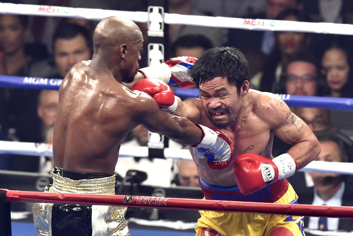 Floyd Mayweather Jr. and Manny Pacquaio trade punches during the fourth round of their May 2 fight in Las Vegas.