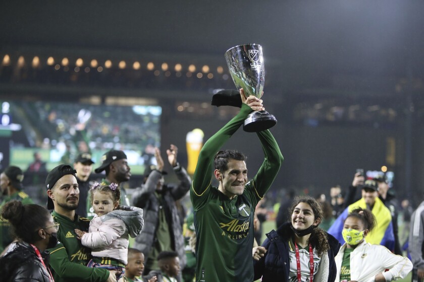 Portland Timbers midfielder Diego Valeri (8) holds up the Western Conference trophy following the team's 2-0 victory over Real Salt Lake in the MLS soccer Western Conference final Saturday, Dec. 4, 2021, in Portland, Ore. (AP Photo/Amanda Loman)