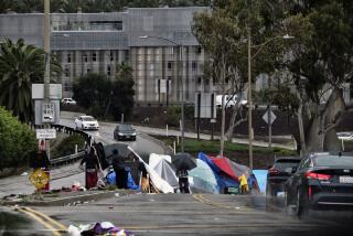 FILE - In this Jan. 14, 2019, file photo homeless shelter from a storm passing over downtown Los Angeles at their encampment along an offramp to the 110 freeway. A federal judge has ordered Los Angeles city and county to move thousands of homeless people who are living near freeways, saying their health is at risk from pollution and the coronavirus. (AP Photo/Richard Vogel, File)