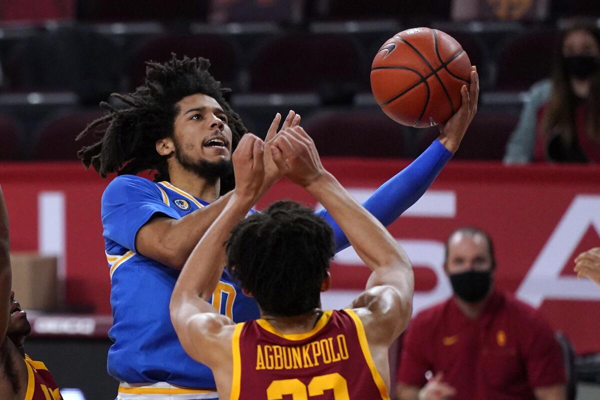 UCLA guard Tyger Campbell shoots over USC forward Max Agbonkpolo during the Trojans' win Feb. 6.