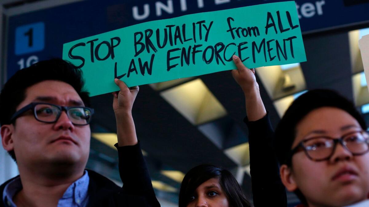 Demonstrators at O'Hare International Airport in Chicago protest the violent removal of a United Airlines passenger from a flight.