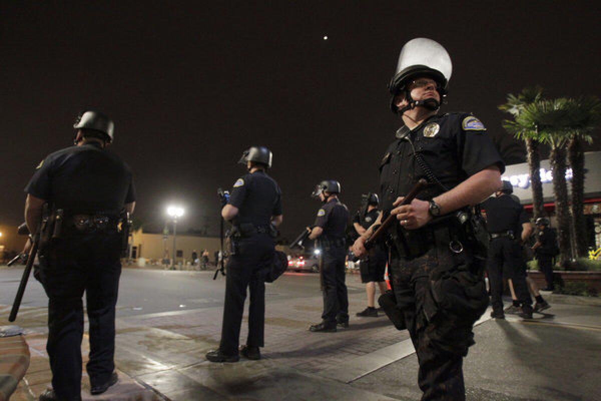 Police make a stand at the corner of Main and Orange Streets after rioters rampaged on Sunday.