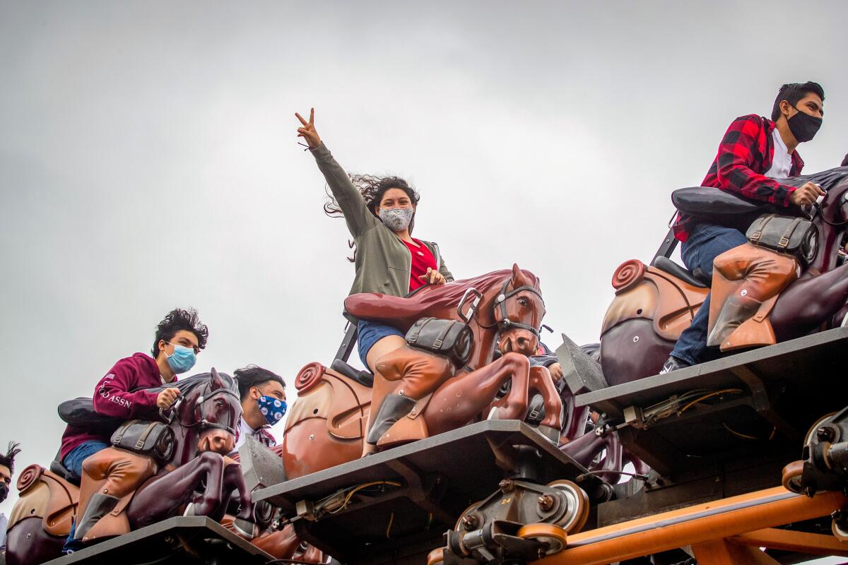 Guests on the horse-shaped ride vehicles of Pony Express.