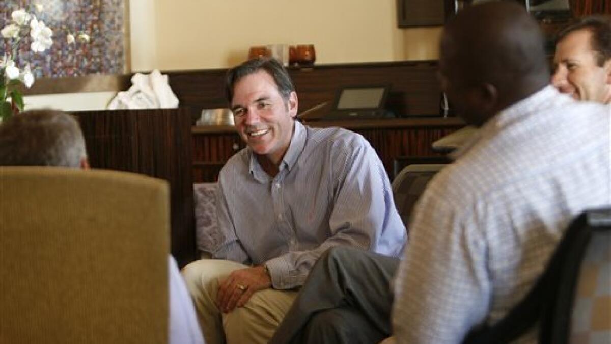 Oakland Athletics' general manager Billy Beane, right, assists