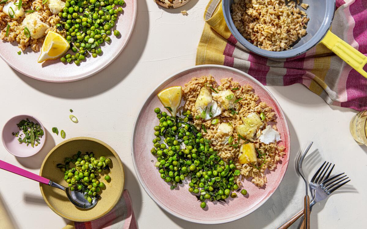 Toasted spices perfume rice and roasted fish in this simple dinner served with peas dressed with lemon and mint. 