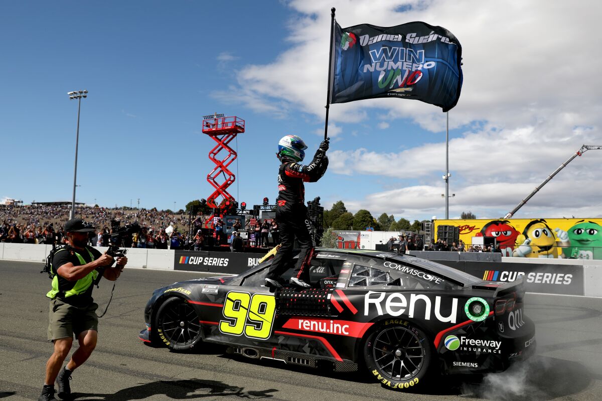 Daniel Suárez waves a flag celebrating his first NASCAR Cup win Sunday at Sonoma Raceway.