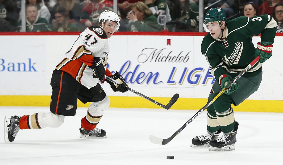 The Minnesota Wild's Charlie Coyle keeps the puck away from the Ducks' Hampus Lindholm during the second period of Saturday's game.