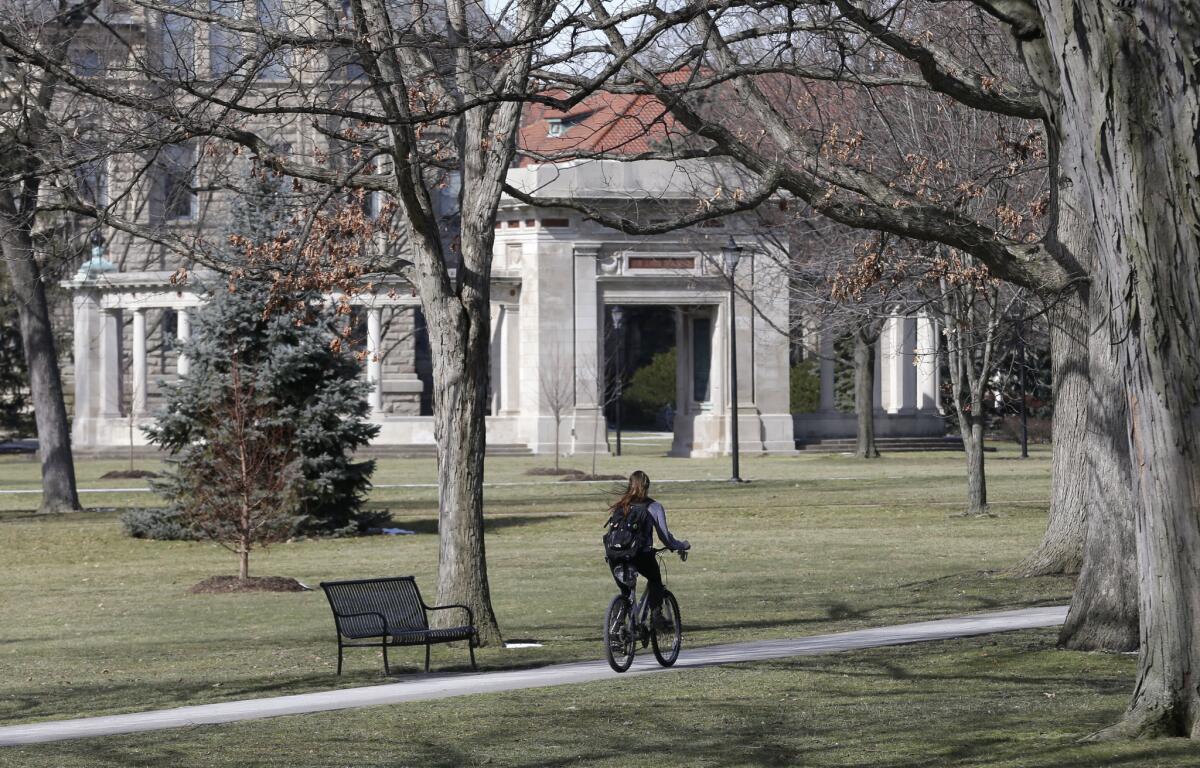 A student rides a bicycle on the campus of Oberlin College.