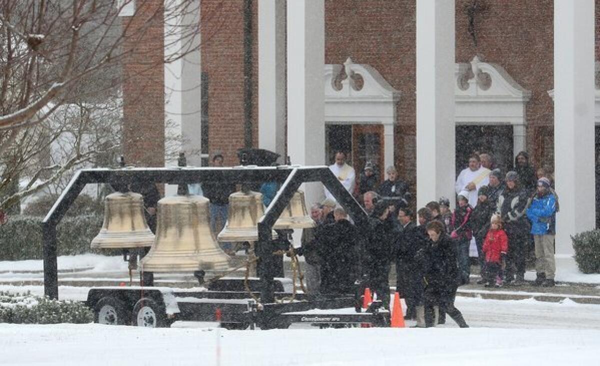 Residents gather outside St. Rose of Lima church as bells ring 26 times and the names of the Sandy Hook Elementary School shooting victims are called over a loudspeaker in Newtown, Conn., on Saturday.