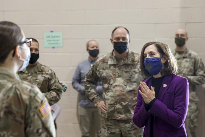 Oregon Gov. Kate Brown visits with National Guard members at a vaccination clinic in Salem earlier this year.