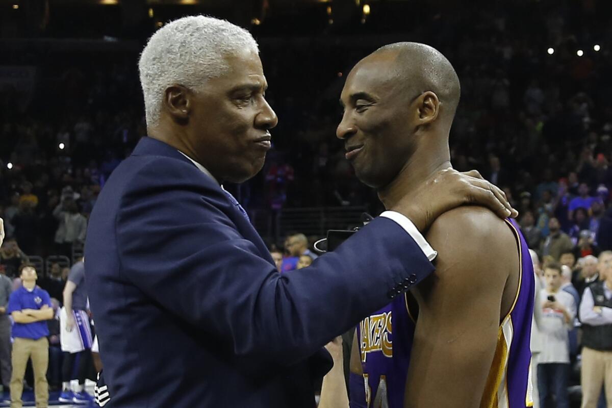 Lakers' aging star Kobe Bryant, right, is embraced by former NBA player Julius Erving before a game against the 76ers.