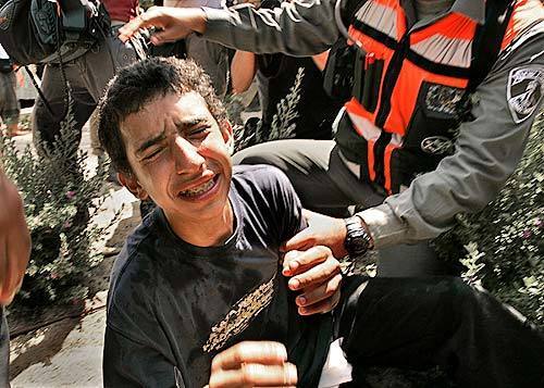 A boy cries as he is detained by police. He and many other protesters were attempting to block the main road in Neve Dekalim.