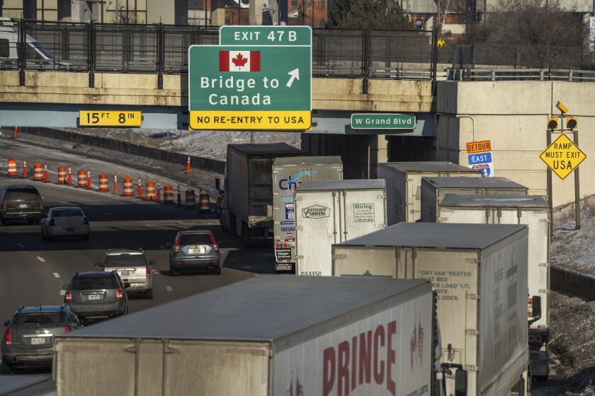 Line of tractor-trailer trucks on freeway in Detroit