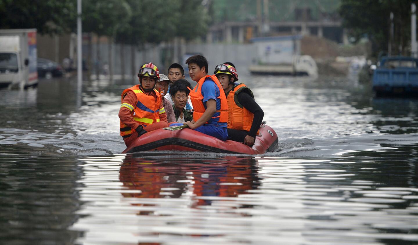 Rescuers transport people along a flooded street in Shenyang in northeastern China's Liaoning Province.