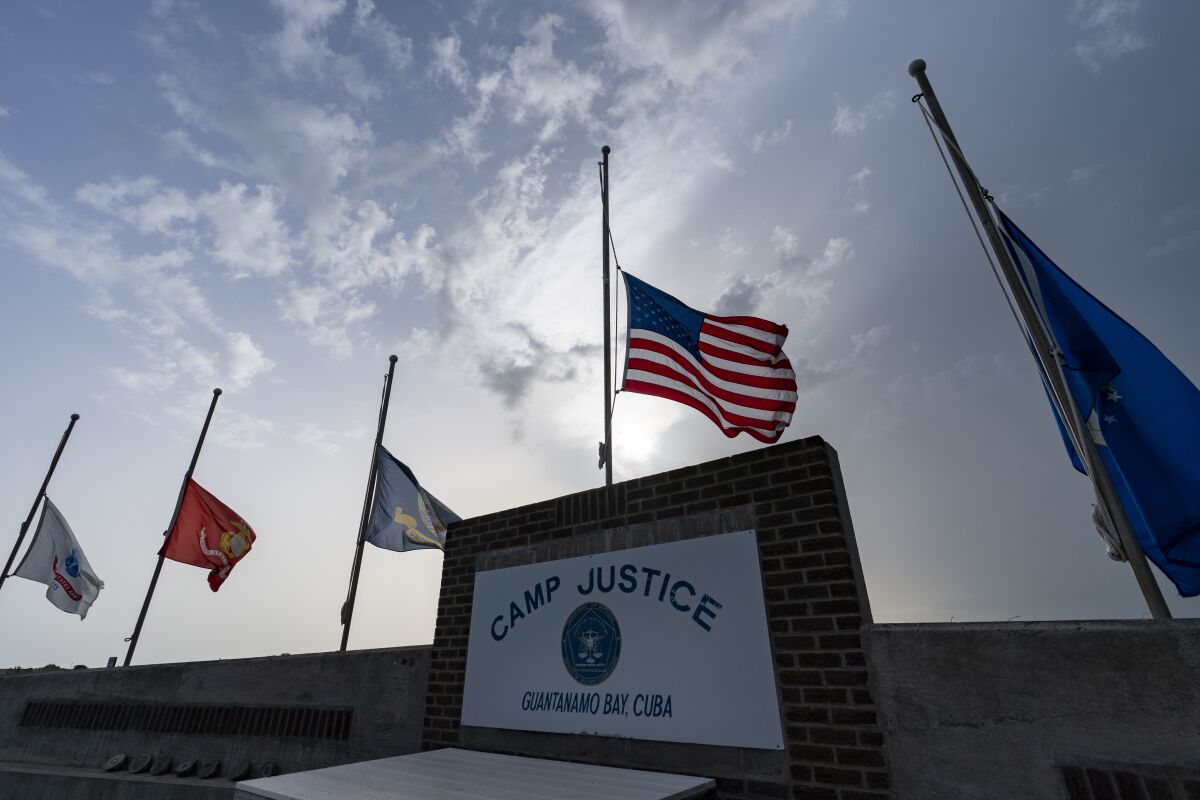 FILE In this photo reviewed by U.S. military officials, flags fly at half-staff at Camp Justice, Aug. 29, 2021, in Guantanamo Bay Naval Base, Cuba. The Defense Department says Sufiyan Barhoumi, an Algerian man imprisoned at the Guantanamo Bay detention center for nearly 20 years, has been released and sent back to his homeland. (AP Photo/Alex Brandon, File)
