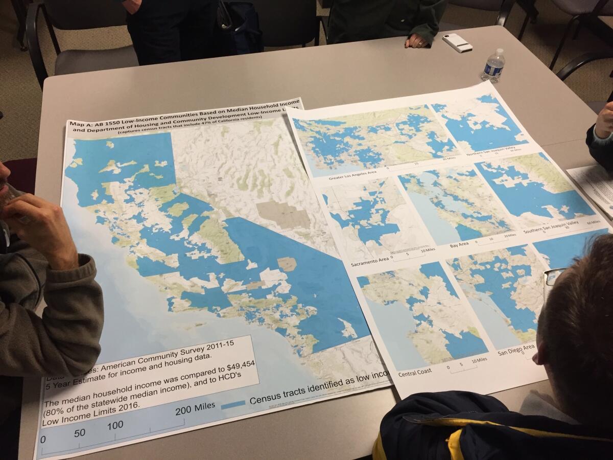 Advocates study a map of low-income areas in California where new spending could be targeted to stem the causes of climate change.