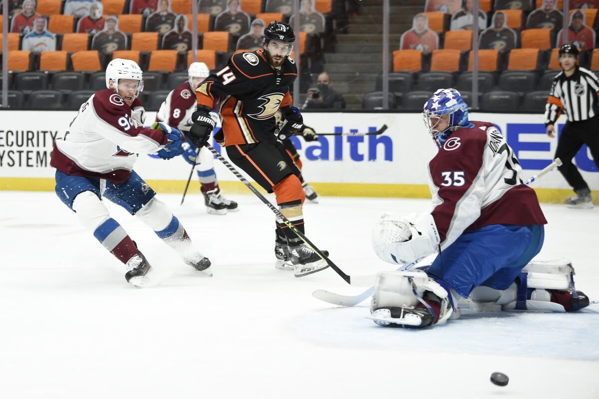 The puck is deflected on a save by Colorado Avalanche goalie Jonas Johansson on April 9, 2021.
