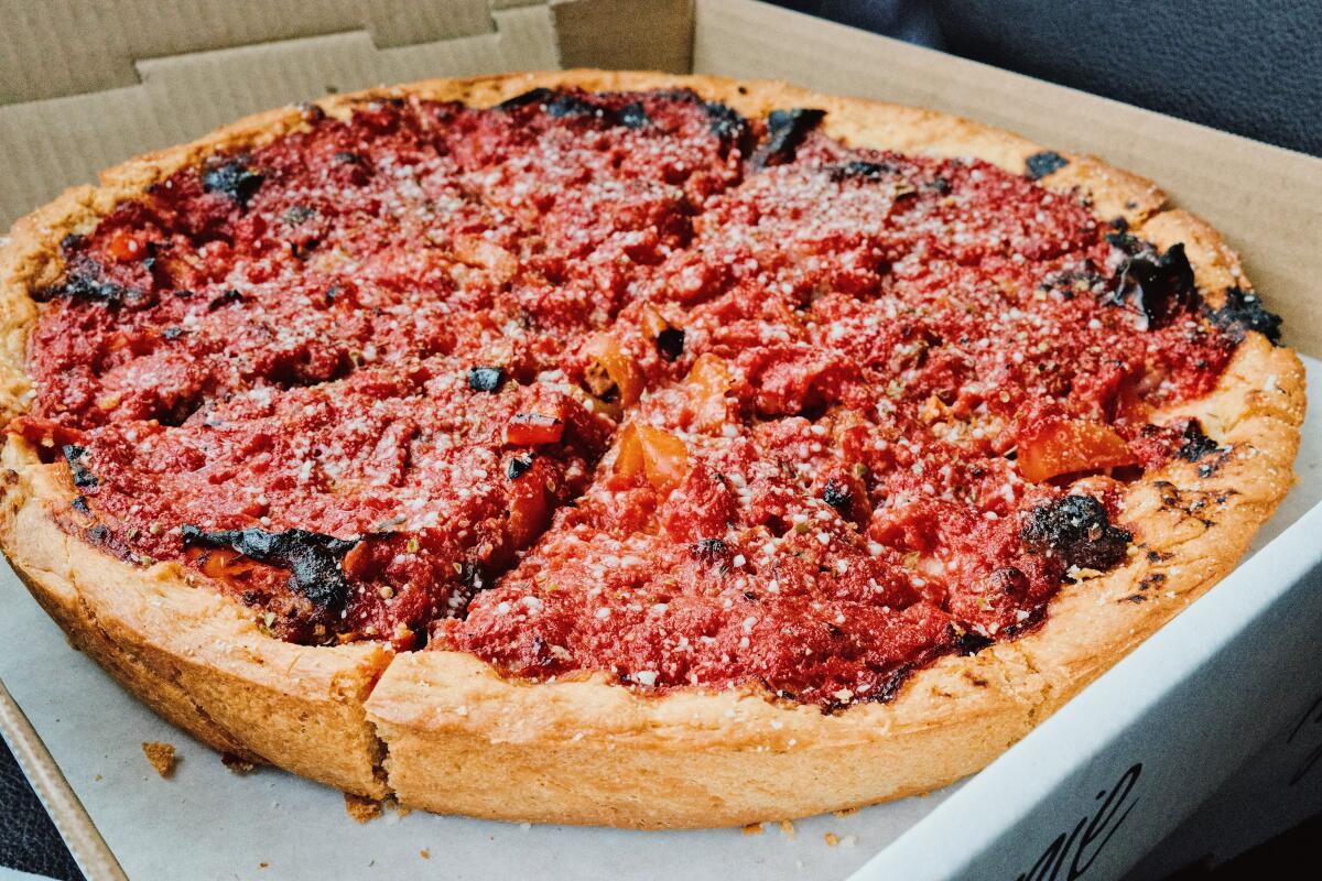 A Chicago-style deep-dish pizza in the to-go box from Doughbox.