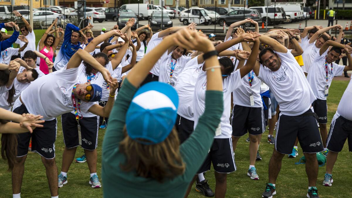 Yoga instructor Elena Schuber leads Special Olympics teams from Brazil and Romania in a stretching exercise in Santa Monica on Wednesday.