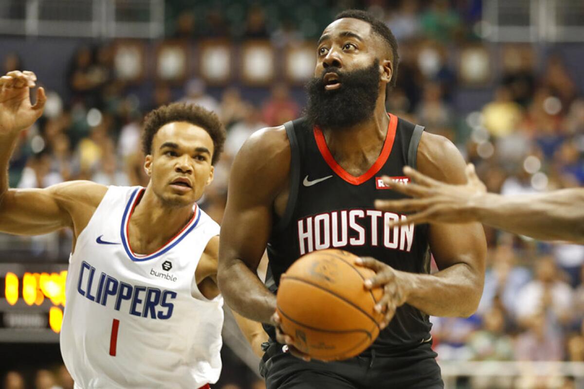 Houston's James Harden gets past the Clippers' Jerome Robinson during the first quarter Thursday night in Honolulu.