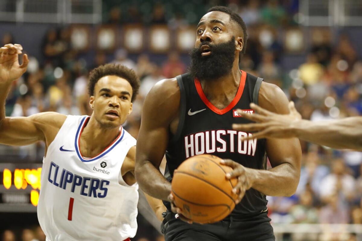 Houston's James Harden gets past the Clippers' Jerome Robinson during the first quarter Thursday night in Honolulu.