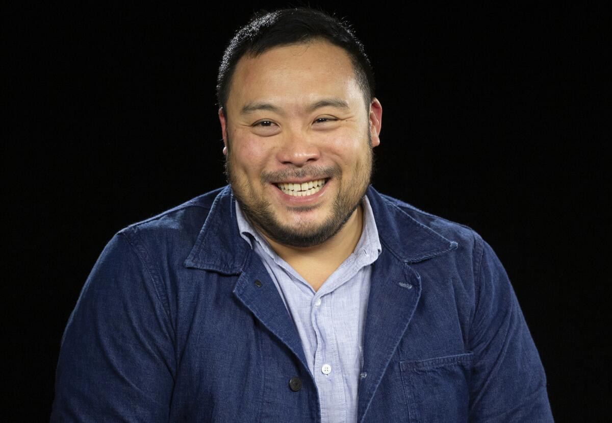 A man wearing a blue jacket smiles