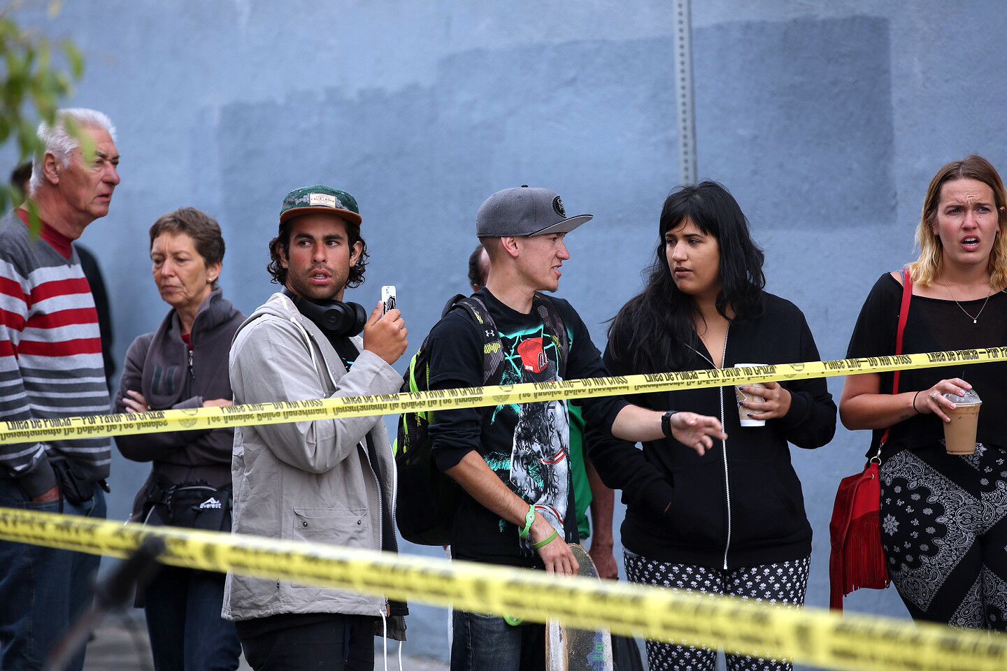 Onlookers stand Wednesday near the site where a man was shot and killed by Los Angeles police officers after a struggle Tuesday night.