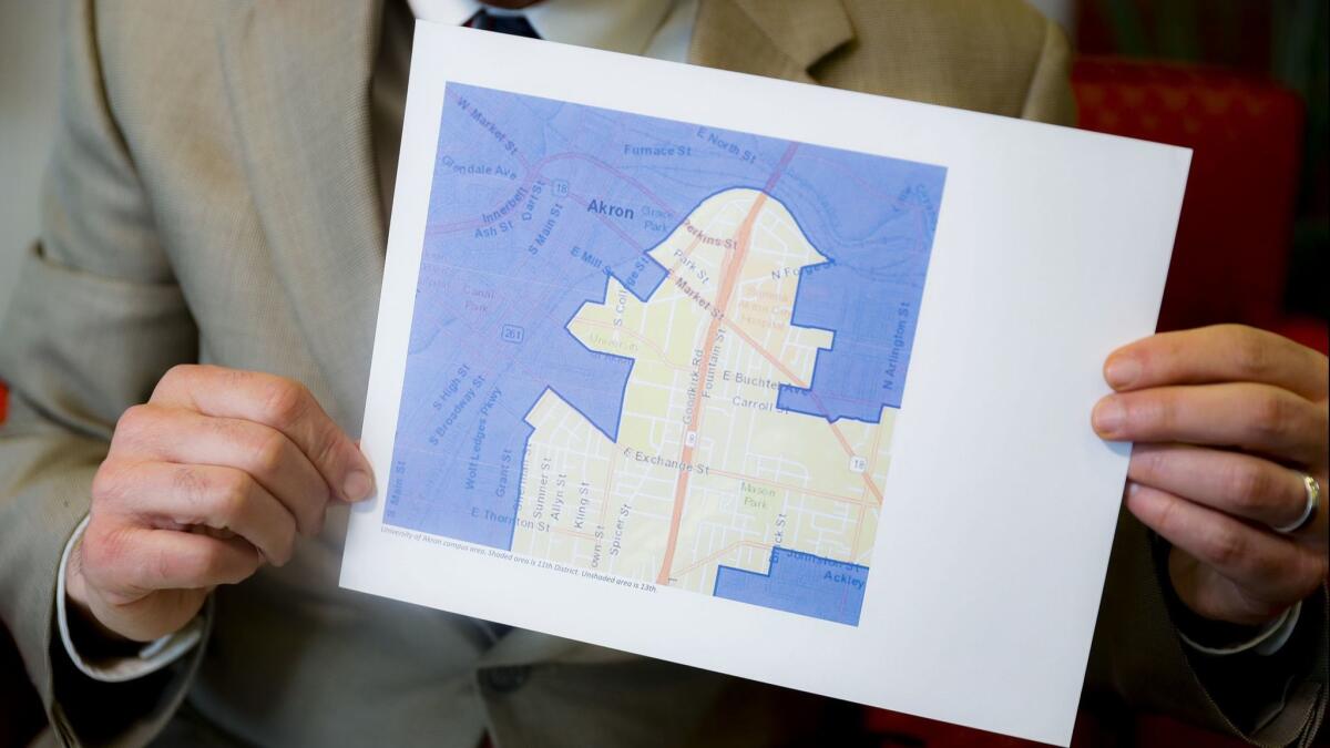 David Niven, a professor of political science at the University of Cincinnati, holds a map illustrating a gerrymandered Ohio district on April 11.