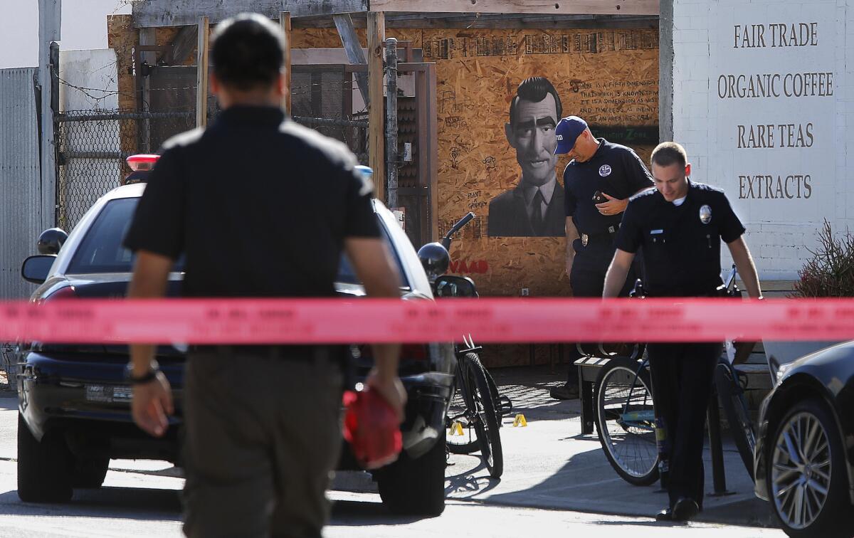 LAPD investigators examine the scene outside a Venice coffee shop where police shot and critically wounded a man Monday afternoon.