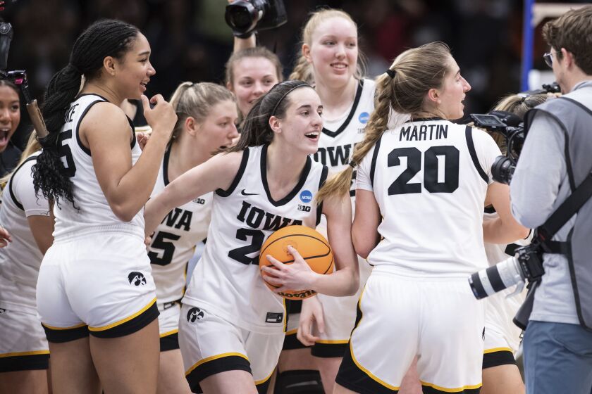 Iowa players, including guard guard Caitlin Clark, front center, forward Hannah Stuelke, front left, and guard Kate Martin (20) celebrate after an Elite 8 basketball game of the NCAA Tournament against Louisville, Sunday, March 26, 2023, in Seattle. Iowa won 97-83. (AP Photo/Caean Couto)