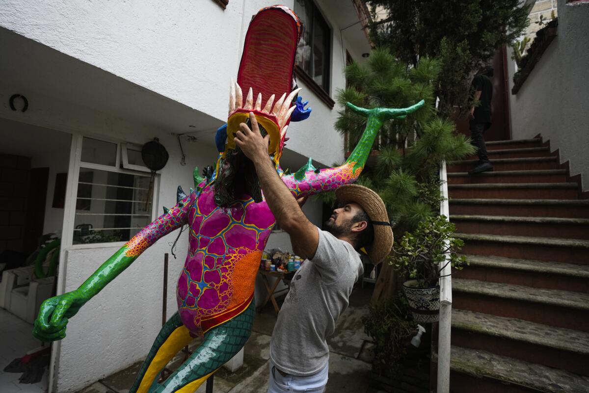 El artista mexicano Israel Mondragón coloca la cabeza de su alebrije en su taller 