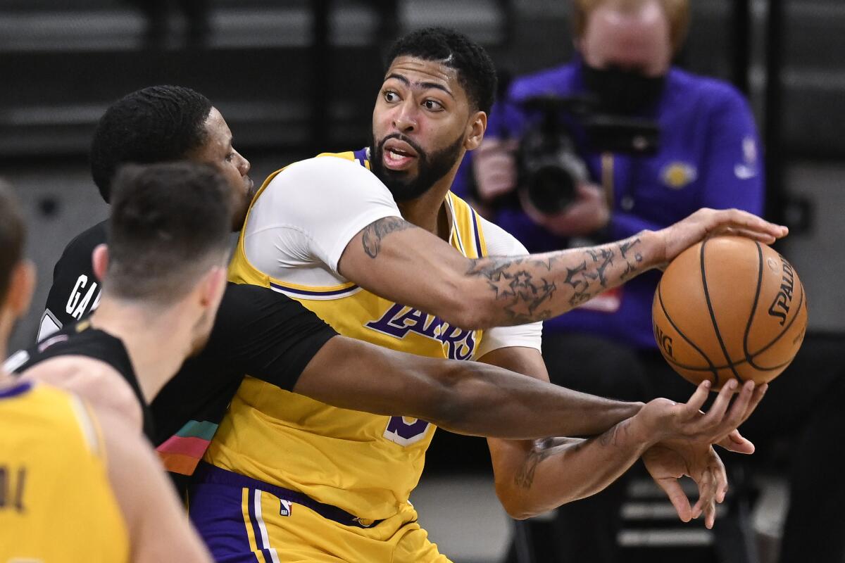 Lakers forward Anthony Davis tries to keep the ball away from San Antonio Spurs forward Rudy Gay.