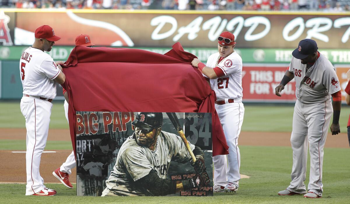 Boston Red Sox's David Ortiz, right, is presented with a painting of him being unveiled by Angels' Albert Pujols. left, and Mike Trout before the game on Thursday. (Jae C. Hong / Associated Press)