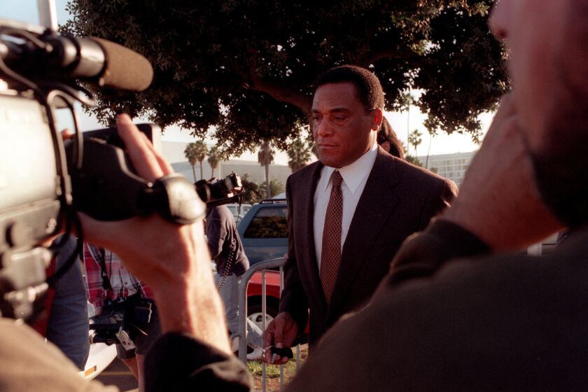 A.C. Cowlings is trailed by the media as he leaves court on Dec. 3, 1996, after testifying in the wrongful death civil suit against O.J. Simpson.