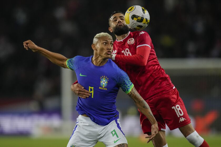 Tunisia's Ghaylen Chaaleli, right, duels for the ball with Brazil's Richarlison during the international friendly soccer match between Brazil and Tunisia at the Parc des Princes stadium in Paris, France, Tuesday, Sept. 27, 2022. (AP Photo/Christophe Ena)