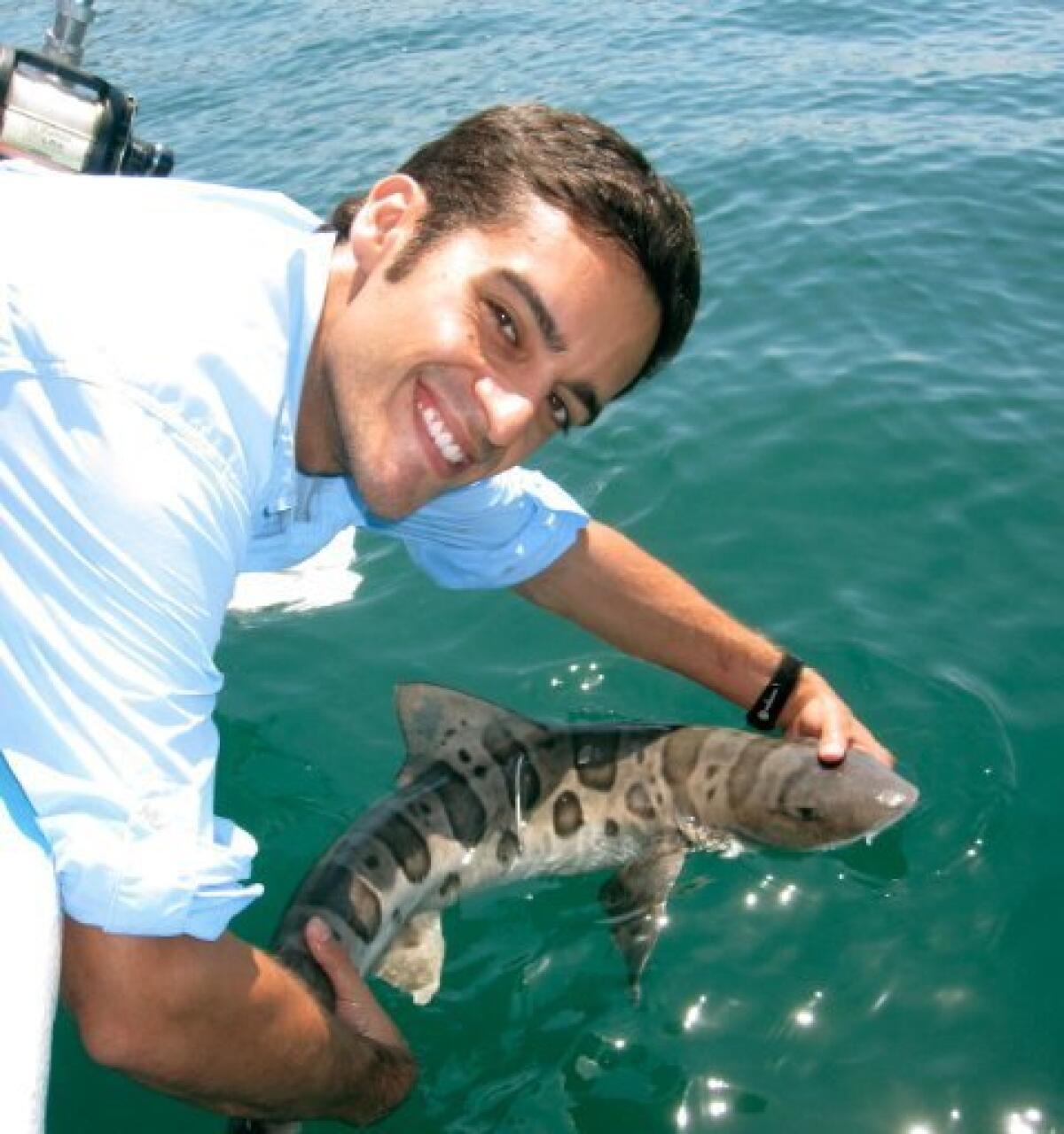Postdoctoral researcher Andy Nosal holds a leopard shark. Birch/SIO