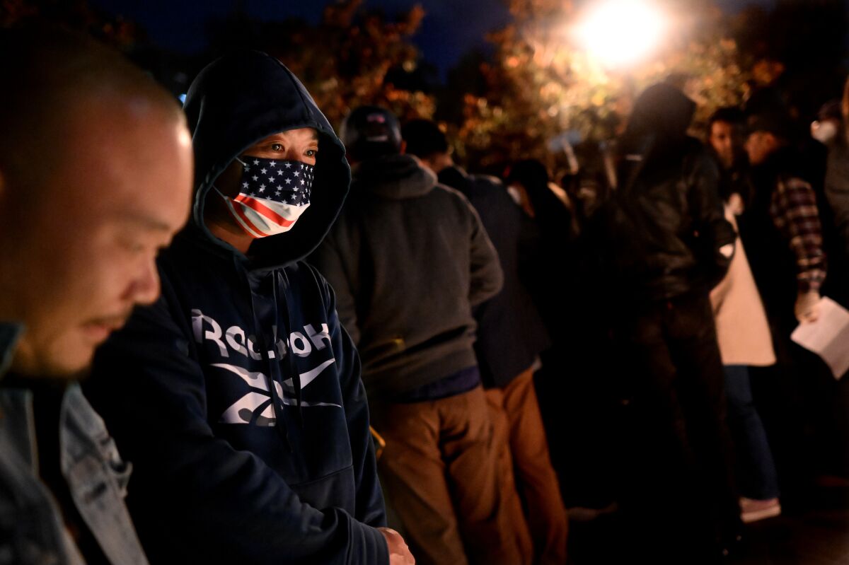 People pay respects at a candlelight vigil at USC to those suffering under China’s stringent COVID-19 lockdowns.