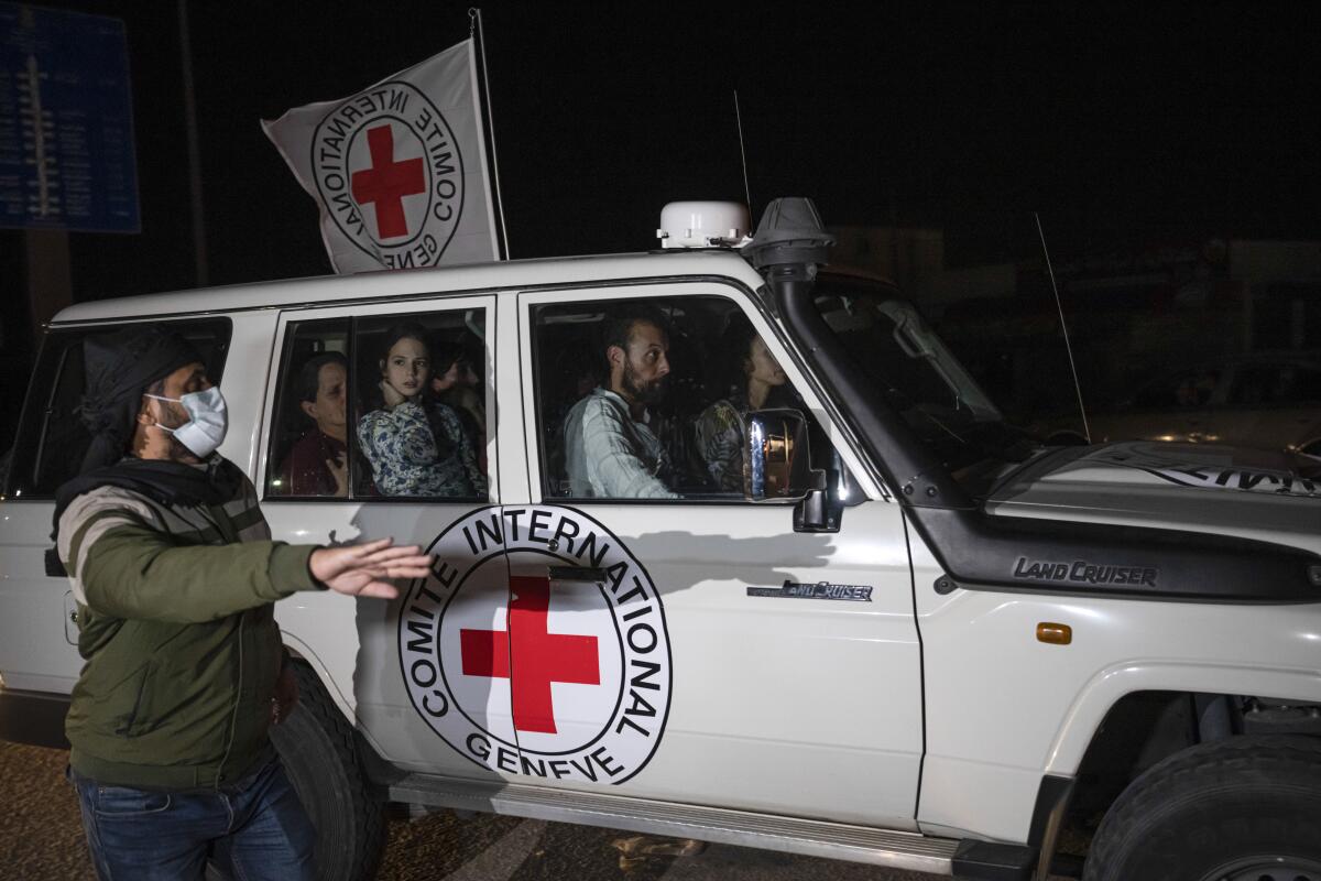 A Red Cross vehicle carrying Israeli hostages travels along at the Gaza Strip crossing into Egypt in Rafah.