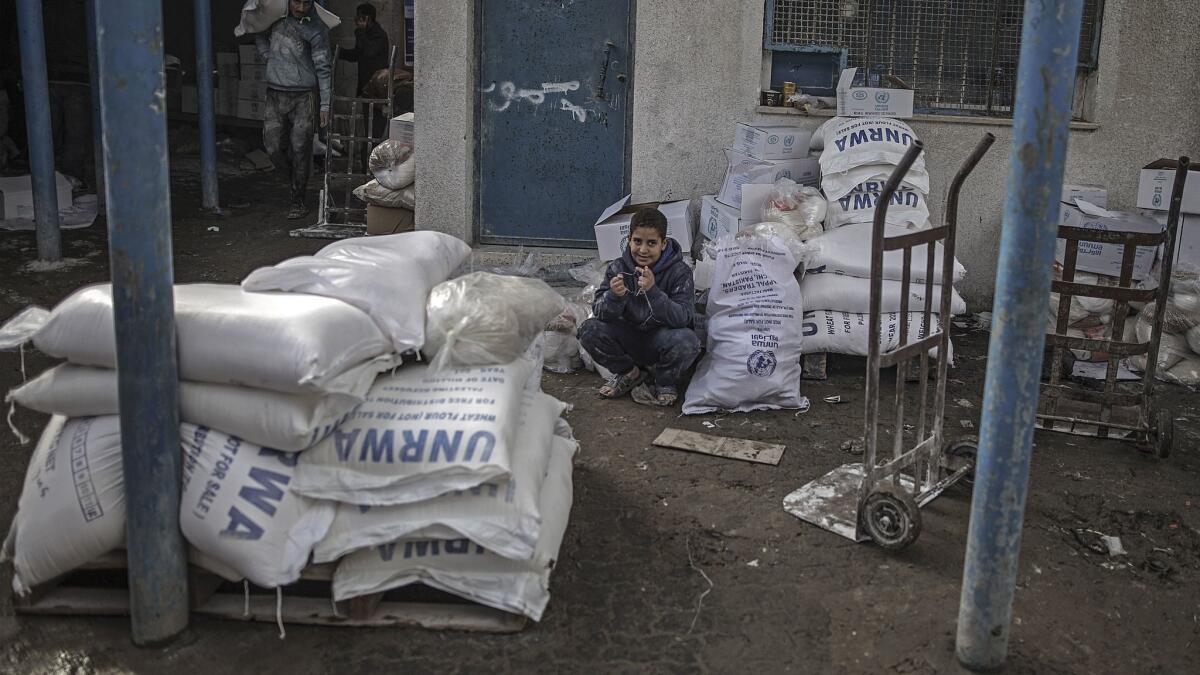 A Palestinian refugee sits near his family's relief supplies in January 2018 at the United Nations food distribution center in Shati refugee camp in northern Gaza City.