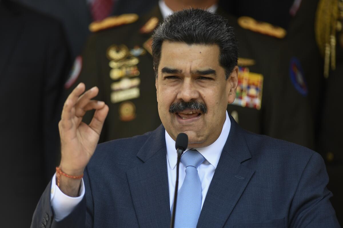 Venezuelan President Nicolás Maduro speaks into a microphone at a news conference